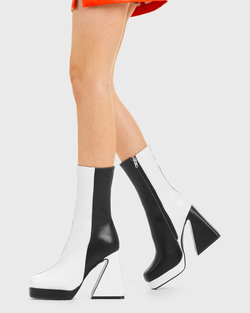 TIME TO DANCE Headturner Platform Calf Boots in Black and white faux leather. These platform boots feature a black and white patch design with a Flared heel, keeping it nice and classy. Made with eco-friendly materials and 100% cruelty-free, these platform boots are as ethical as they are chic. - Platform Height - Calf length - Patch design - Flared heel - High Heel - 100% vegan SKU: LMF 3773 - BlackPU/WhitePU