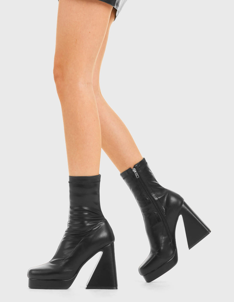 SHOE GAME Old Me Platform Ankle Boots in Black Faux Leather. These vegan western Boots feature a Minimalist design with a flared heel, perfect for a good time out. Made with eco-friendly materials and 100% cruelty-free, these boots are as ethical as they are Chic! - Platformed high heel - Calf length - Fitted feel - Rounded toe - 100% vegan SKU: LMF 3774 - BlackStretchPU