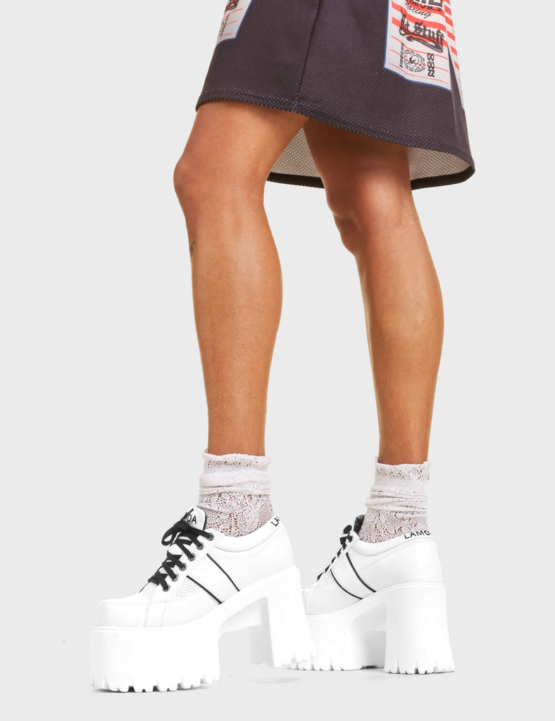 Easy Going Chunky Platform Sneakers in white. Features black stripe detailing and lace-up fastening, with 'LAMODA' in black on the tongue and heel of the shoe.