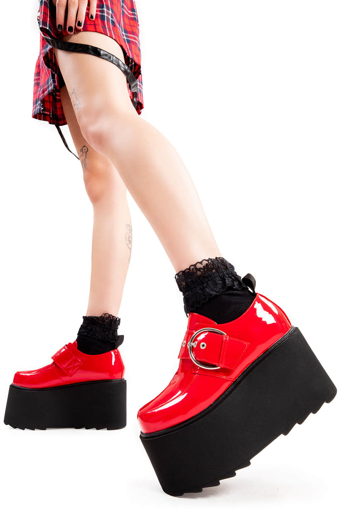 Step Out in Fashion
 
 Grounded Chunky Platform Shoes in Red Patent. These flatform shoes feature a large strap with a large silver 'O' ring buckle. Made with eco-friendly materials and 100% cruelty-free, these platform boots are as ethical as they are Edgy
 
 - Platform Height
 - Large strap
 - Silver buckle and eyelets
 - Flatform Sole
 - Shark's Teeth Grip
 - 100% vegan 
 
 SKU: LMF 3133 - RedPAT