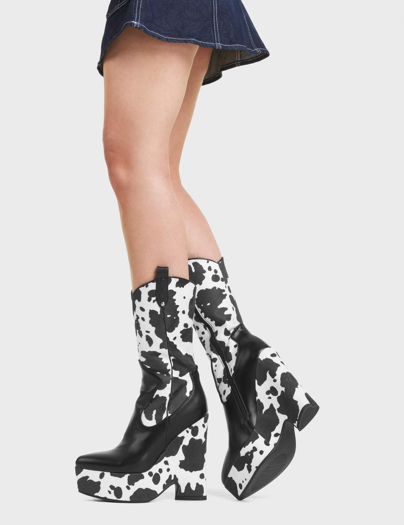 Here We Are Chunky Platform Calf Boots feature a cow print design, and features a heart shaped heel.