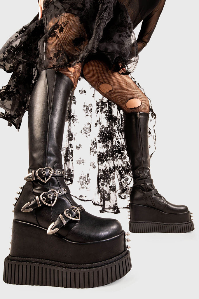 Defy Gravity

Landslide Knee High Flatform Boots in Black faux leather. These black vegan Flatform Boots feature on our chunky flatform creeper sole with three adjustable straps with heart shaped buckles and silver eyelets, defy the ordinary in these boots. 

- Platform Height: 5.3 inch
- Black zipper 
- Black strap and silver eyelets
- Heart shaped buckles 
- Silver studs
- Gusset detail
- Wide ankle and calf friendly 
- Chunky flatform creeper sole
- Round Toe
- 100% vegan 

SKU: LMF 1878 - BlackPU
