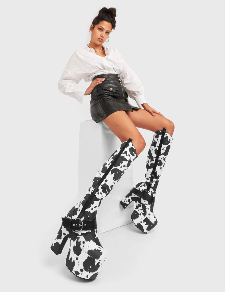 ANIMALISTIC

Rhinestone Cowboy Chunky Platform Knee High Boots in Cow Print faux suede. These vegan Platform Boots feature an ICONIC western cow print on a Chunky Platform sole and heel, also features a adjustable strap across the front. Made with eco-friendly materials and 100% cruelty-free, these boots are as ethical as they are wild!


- Platform Height: 
- Heel Height: 
- Cowprint Design
- Knee High Length 
- Black Zipper
- Platform Sole
- Pointed Toe
- 100% vegan

SKU: LMF 5118 - Cowprint