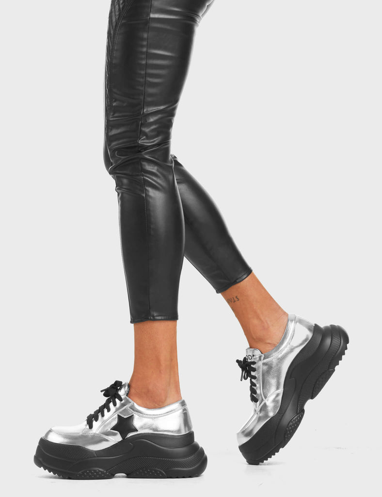 Venus Chunky Platform Sneakers in Silver. Feature black lace-up fastening and a black star.